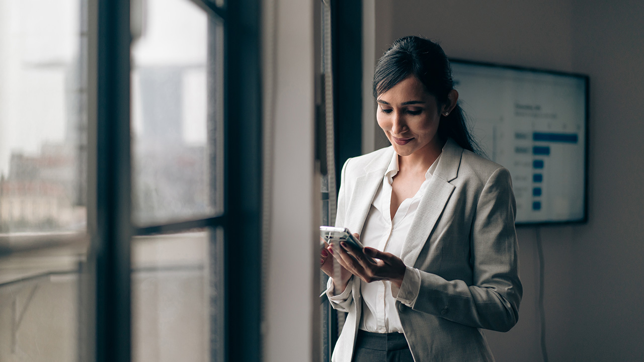 Woman looking on her phone near window